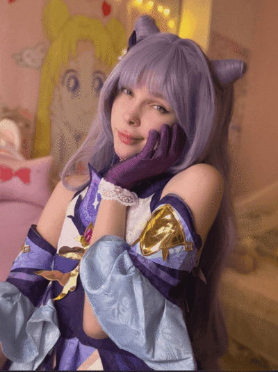 Young woman in lavender cosplay with cat ears and matching gloves, resting her head on her gloved hand in a pastel, softly lit room.